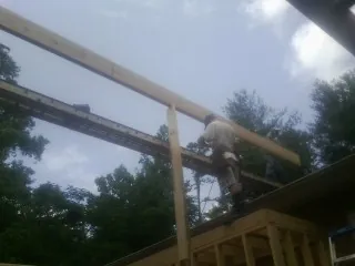 Carpenter setting a ridge beam over a new addition frame — Ice Dam Removal by Roofing Brothers in Perry Point