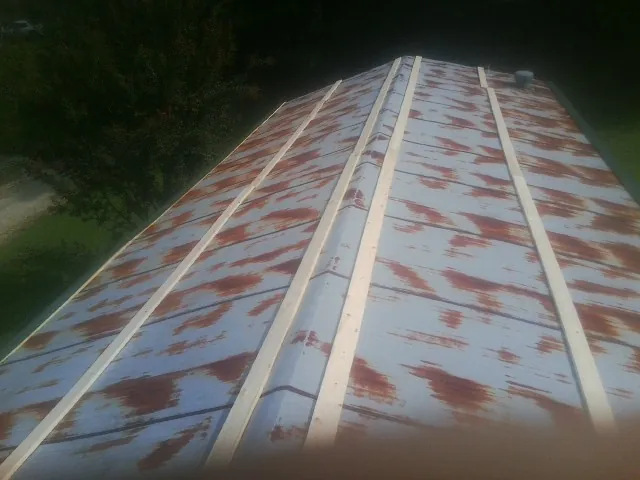 Rusted metal roof panels with new wood purlins before replacement — Storm Damage Roof Repair in Perry Point by Roofing Brothers