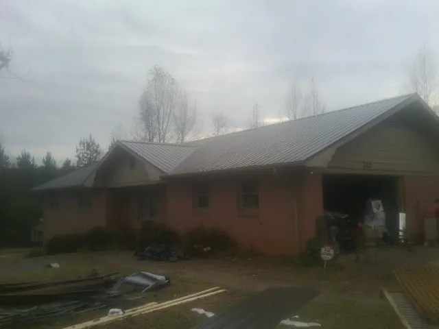 Gray metal roof on a stucco house with an attached garage in Perry Point