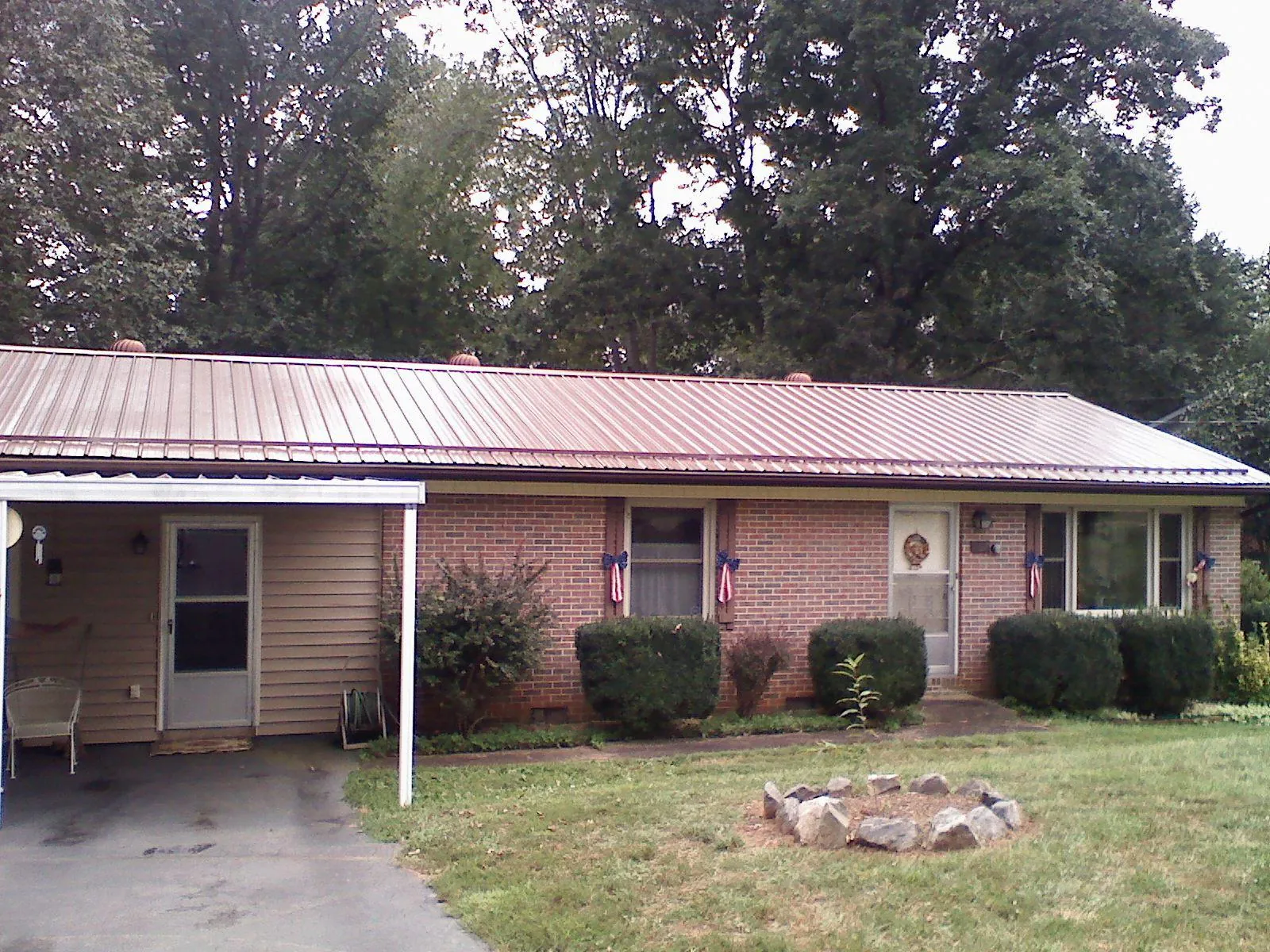 Bronze metal roof and carport on a brick ranch home — Roof Repair work by our crew in Perry Point